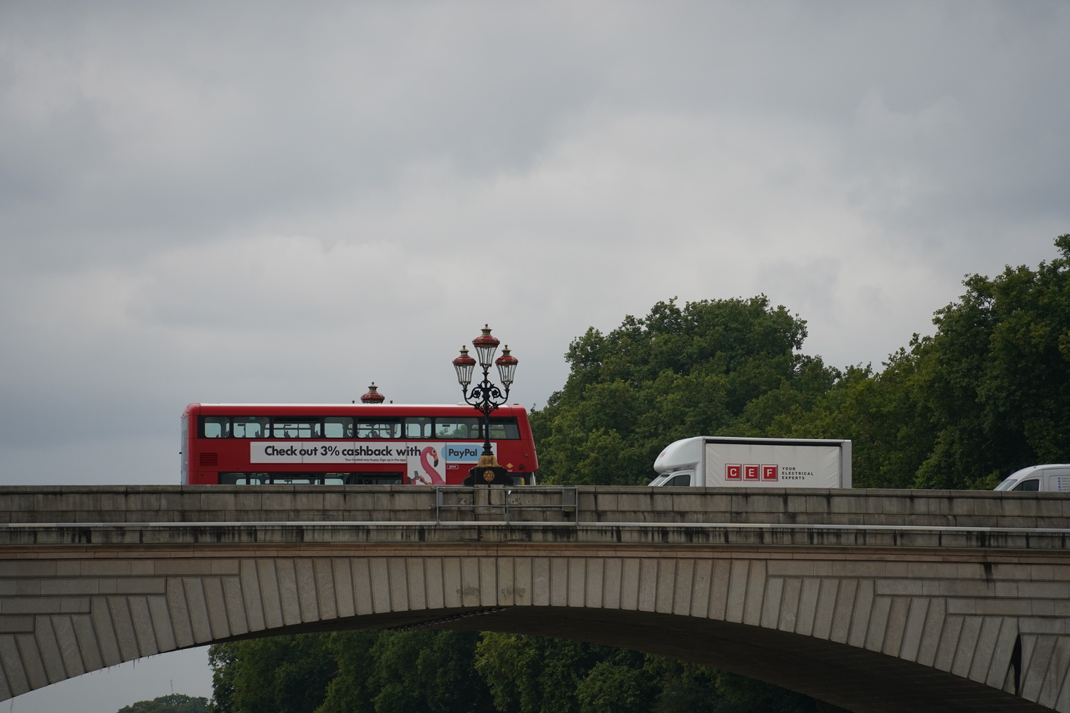 An image of a classic red London city bus as it crosses a bridge over the Thames.